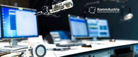 Das Moderationspult in einem Radiostudio mit Mikrofonen, Kopfhörern und Monitoren